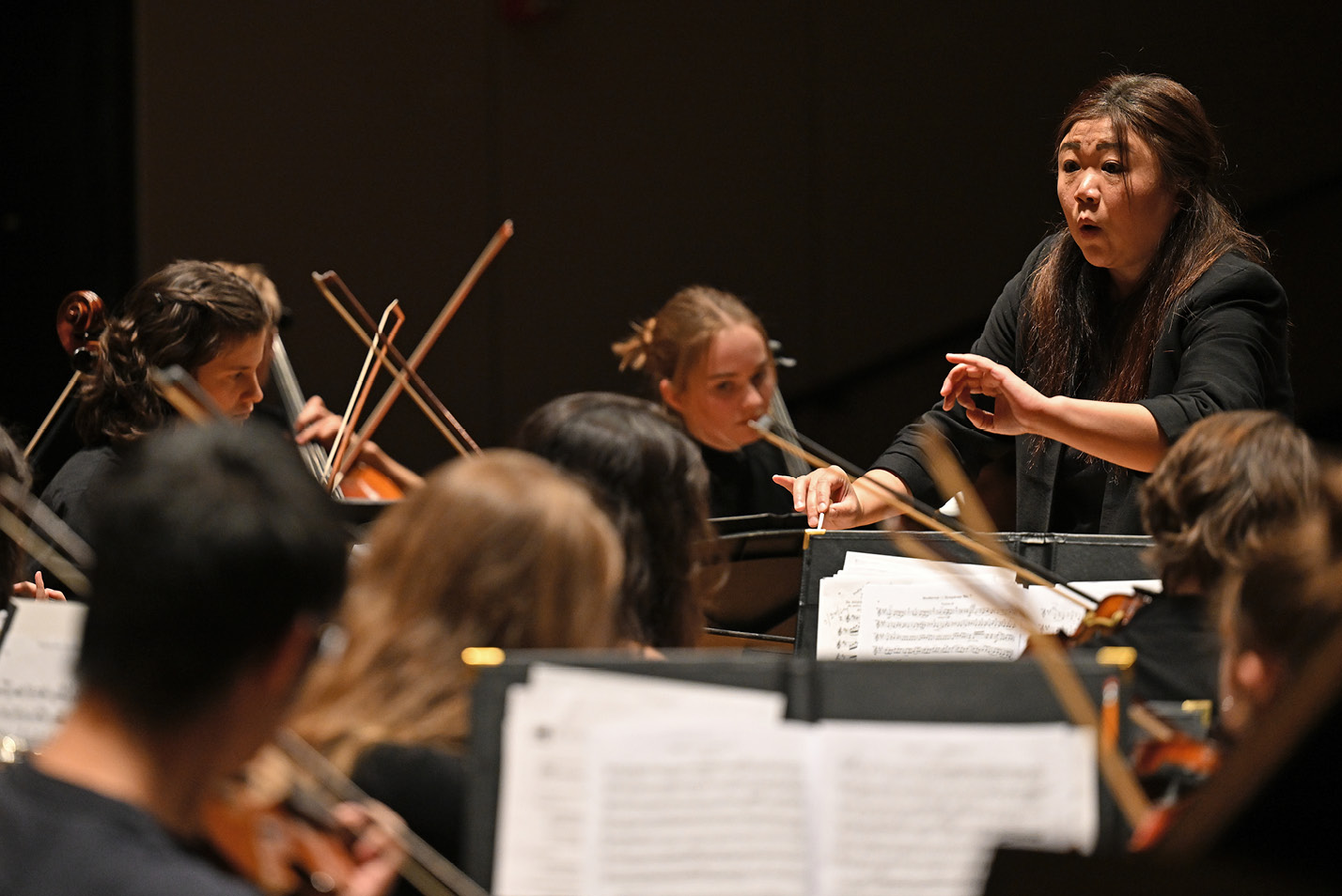 Conductor conducts a student orchestra event at Fall Weekend 2024