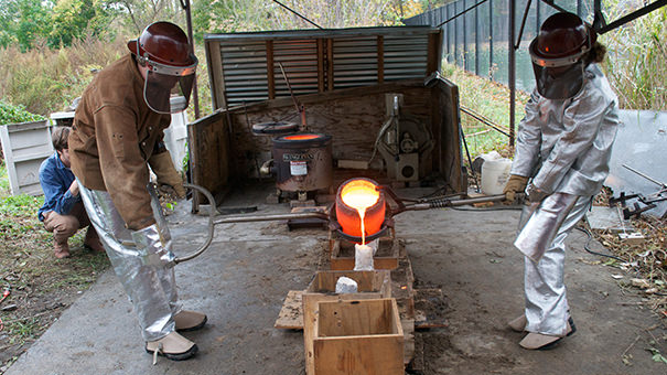 Art students participating in a bronze pouring demo. 