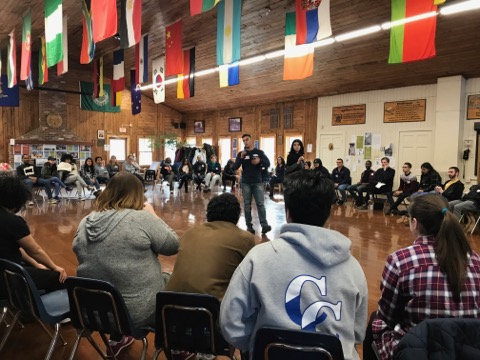 students sitting in a circle listening to a speaker