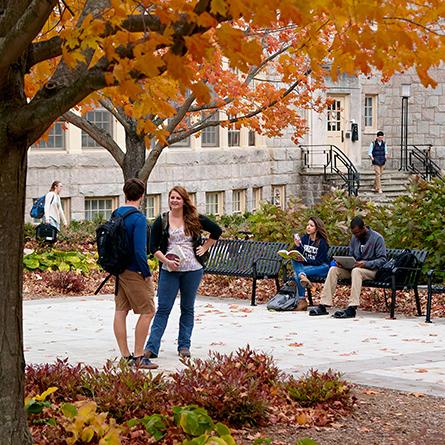 A beauty shot of students talking in front of a campus building. 