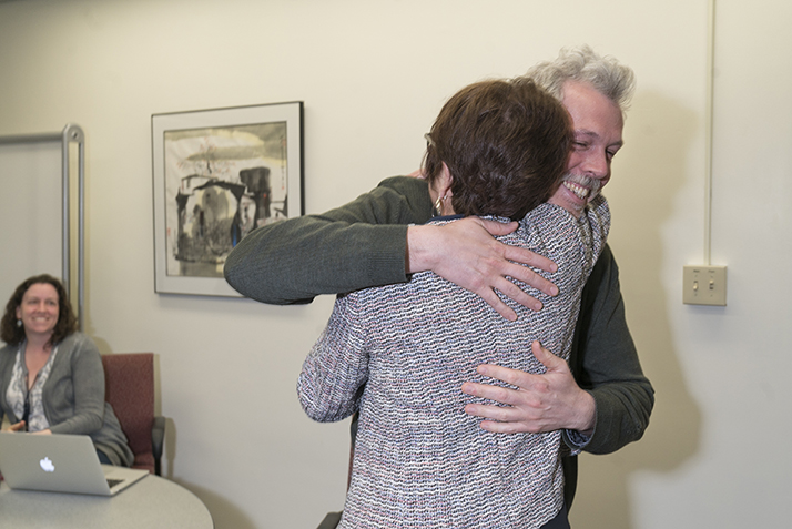 Research and Instruction Librarian Andrew Lopez hugs President Katherine Bergeron after she surprises him with the Student Support Award. 