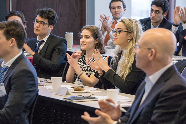 Students applaud during final presentations as Cohen, foreground, looks on. 