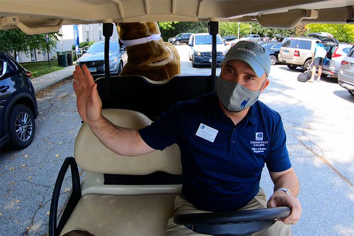 A Conn employee waves from a golf cart