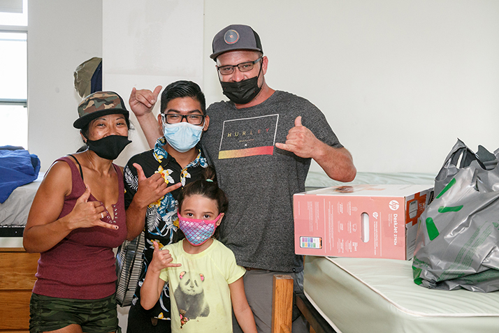 A new student poses with his family as they help the student move in.