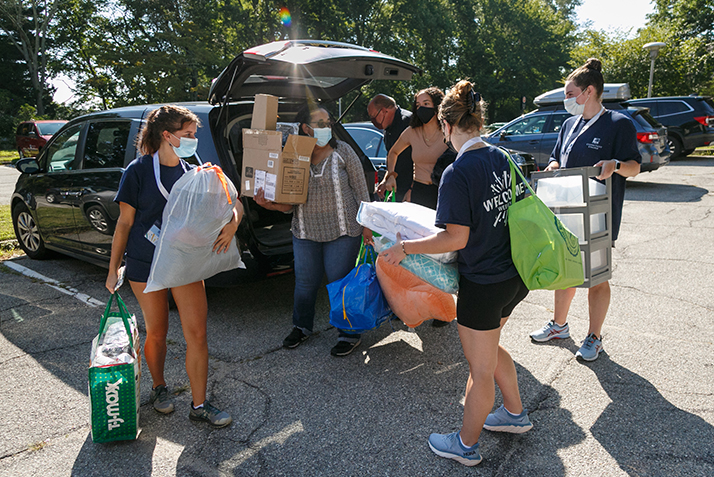 Student leaders help a new student unload their car.