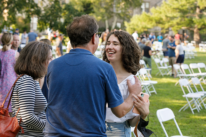 A student hugs her parents goodbye.