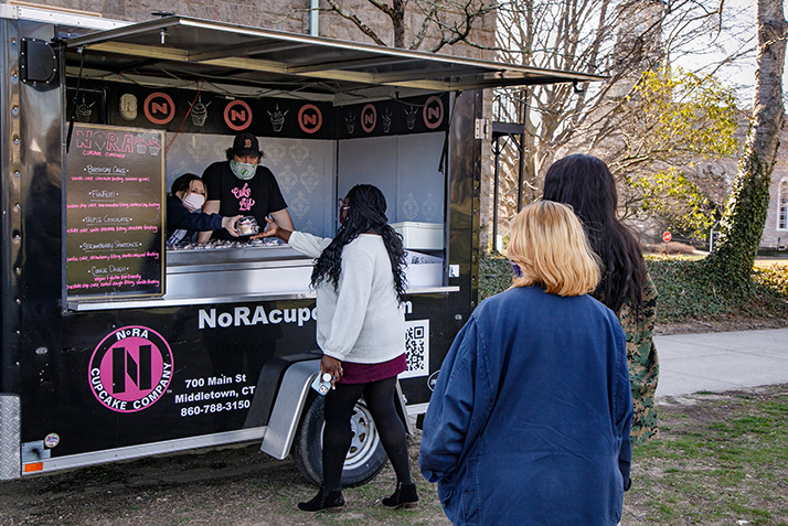 Members of the community wait in line for cupcakes. 