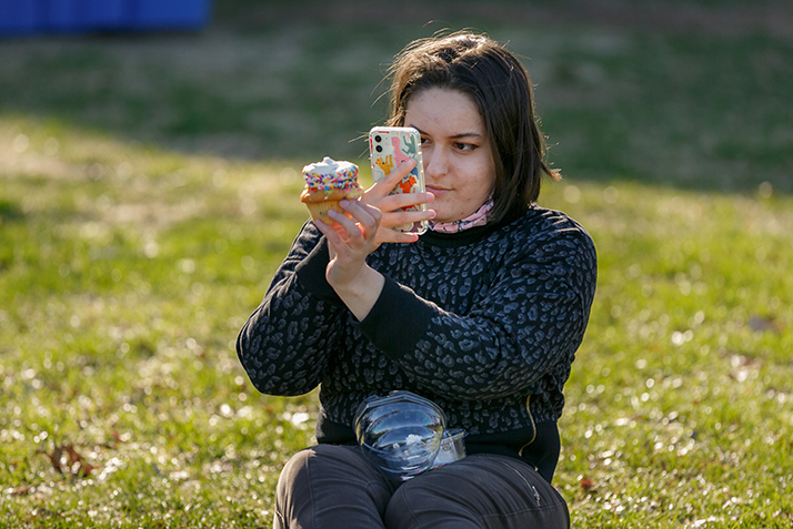 A student takes a photo of a cupcake. 