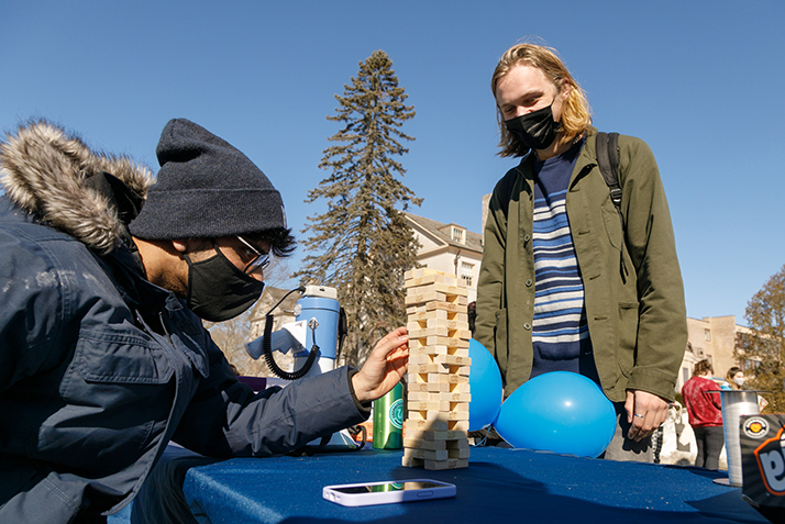 Two students play Jenga outside.