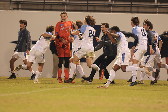 Players converge on the goalie after winning the game. 