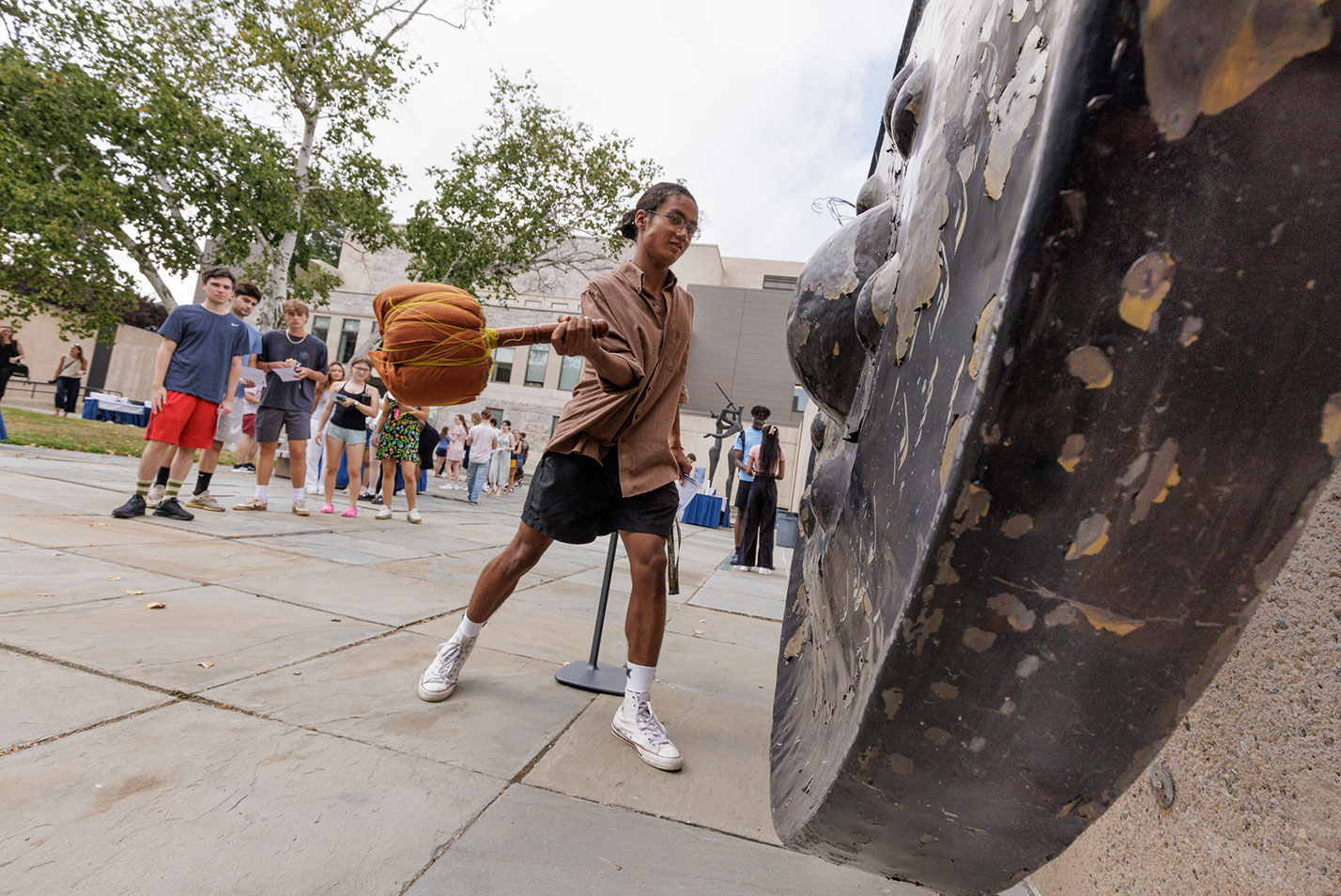 A new student rings the gong.