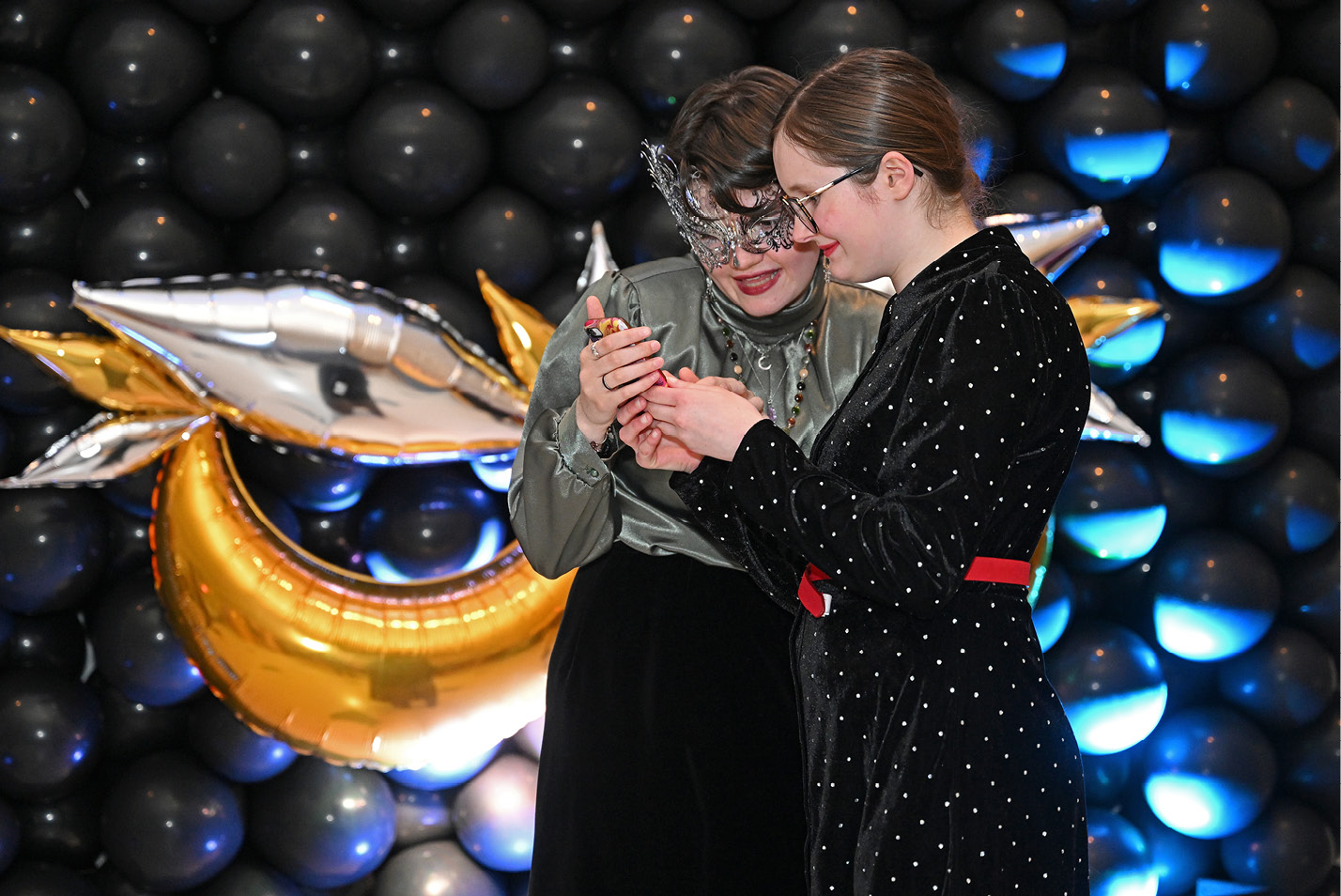 Students take selfies at the winter formal masquerade ball sponsored by the Student Activities Council in the 1962 Room.