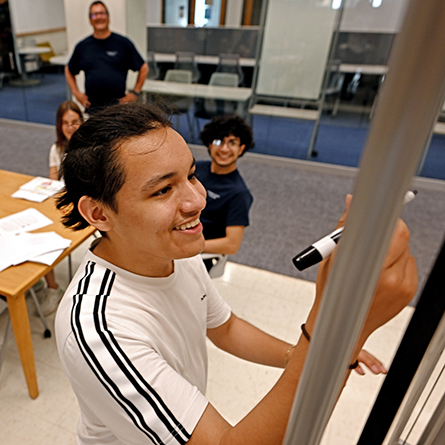 Giovani Salazar takes a turn at the white board during the Venture Incubator program.