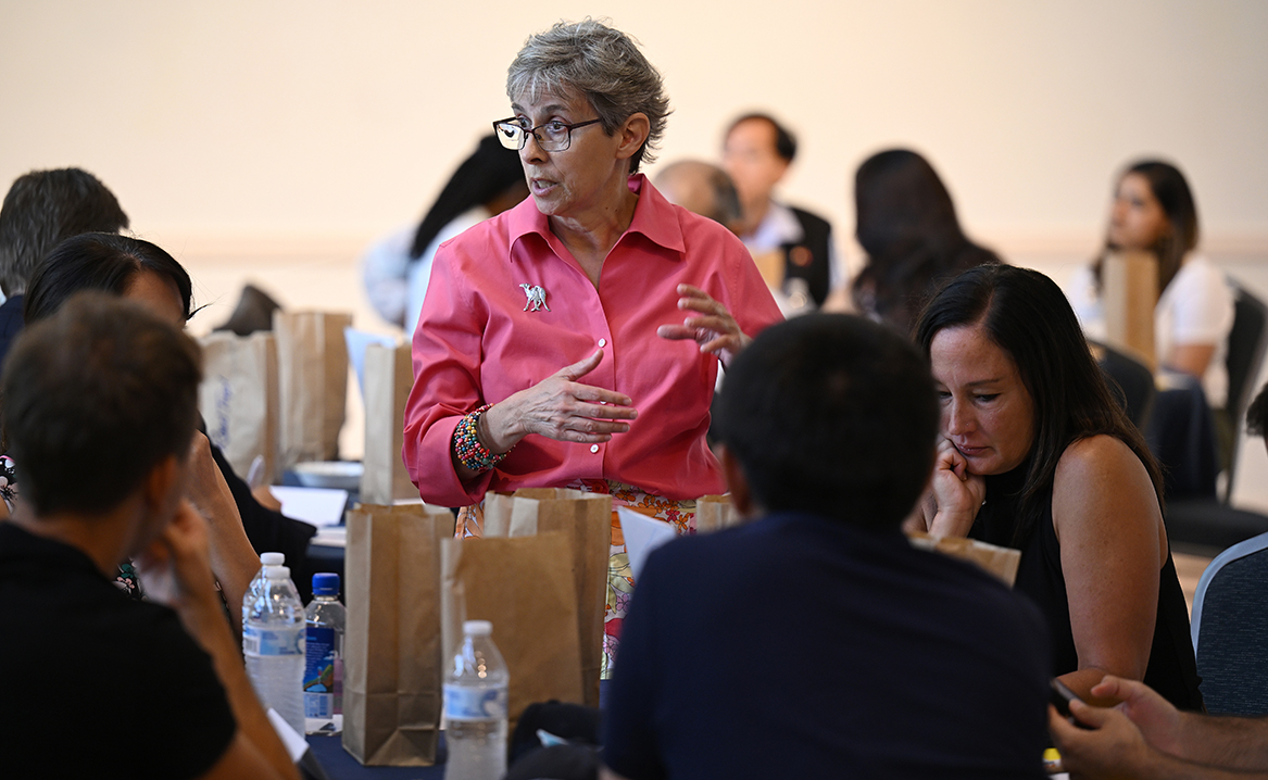 MaryAnne Borrelli, Susan Eckert Lynch ’62 Professor of Government, left, checks-in with the group of United States Department of State Study of the United States Institutes (SUSI) foreign policy program scholars portraying members of the National Security Council.