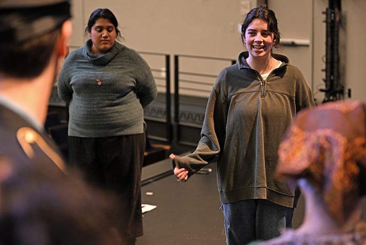 two people standing and talking toward the viewer