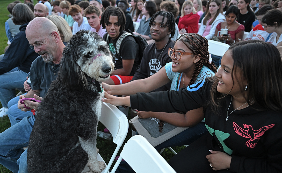 Students pet Koda, President Chapdelaine's dog, at a Welcome Weekend event on Tempel Green.