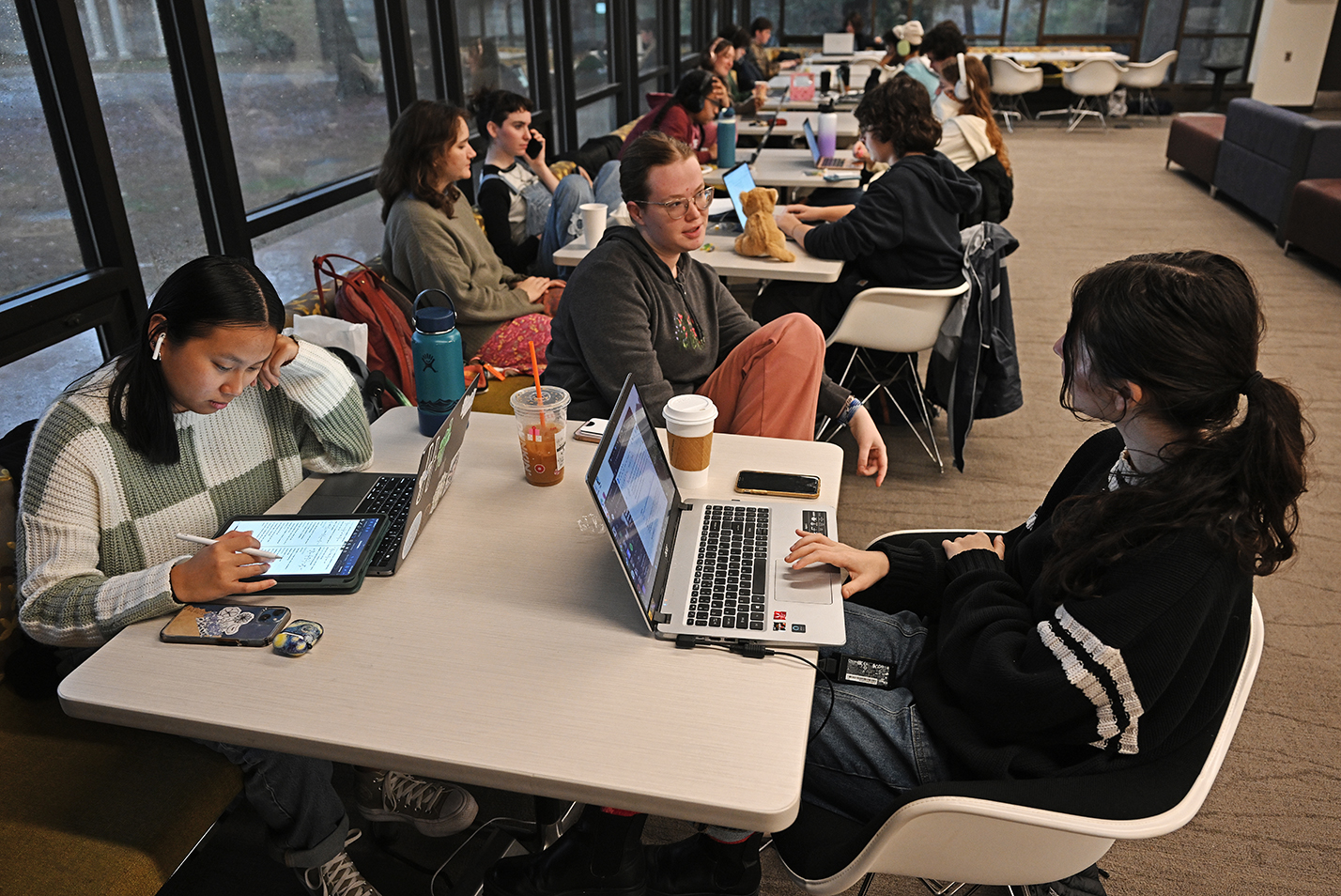 Students work around a row of tables as they study for finals.