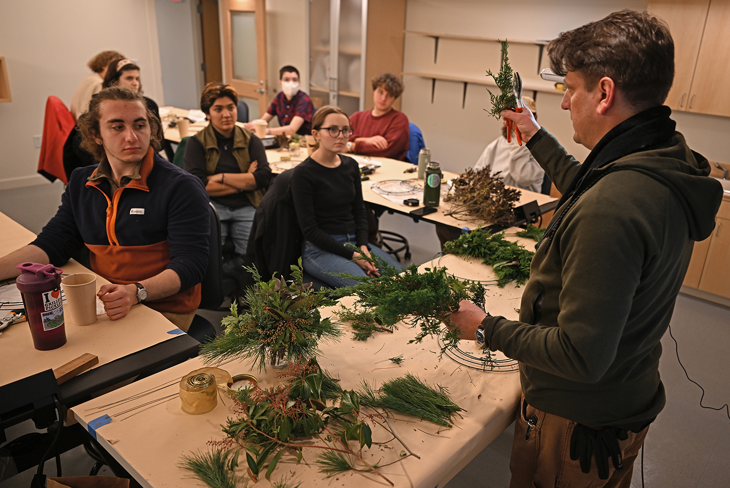 A staffer leads a wreath-making workshop for students.