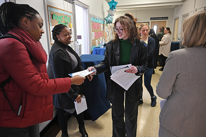 Student Accessibility Services Fellow Alex Eikinas ’26 hands out programs prior to the grand opening celebration.